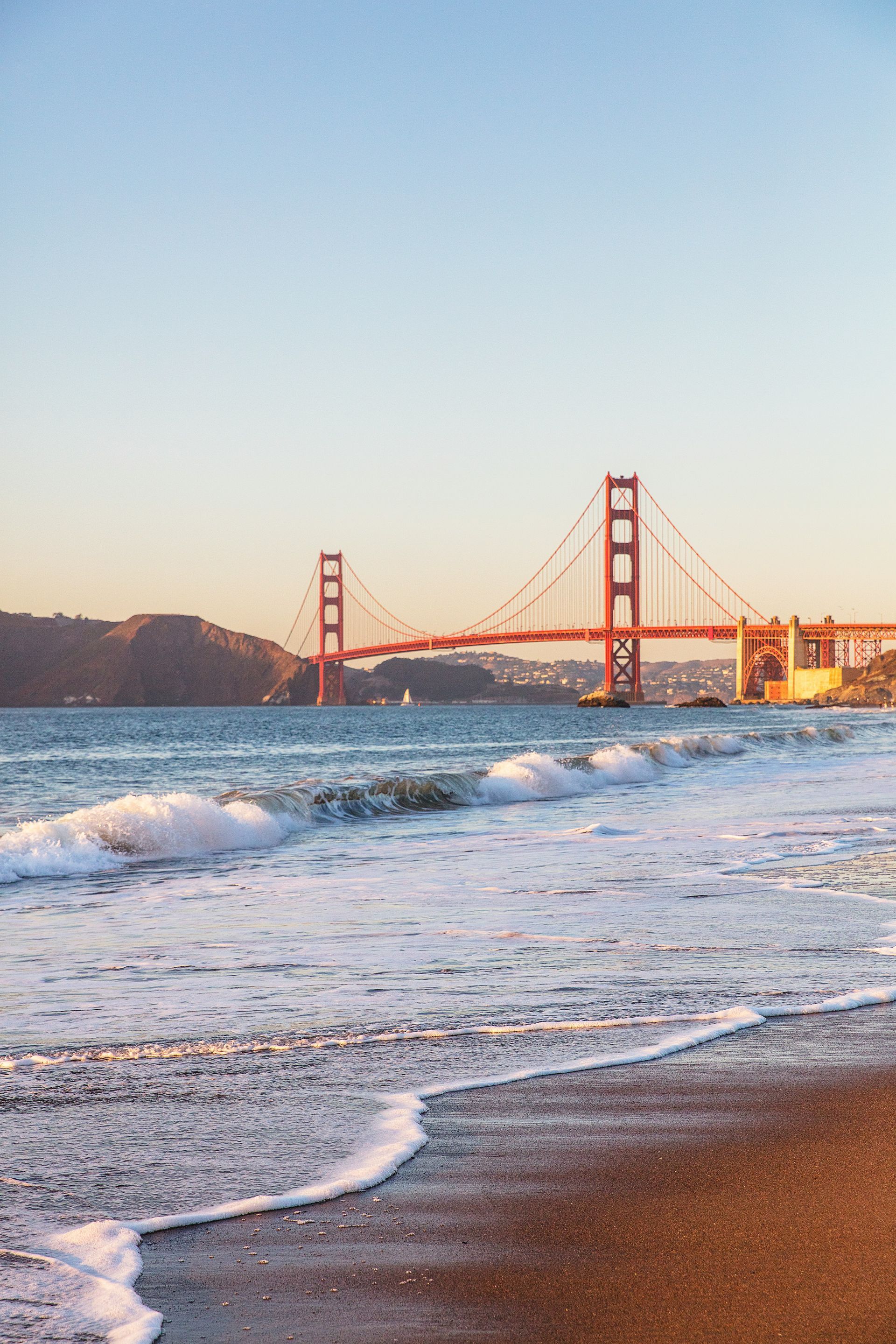 A beach with a golden gate bridge in the background.