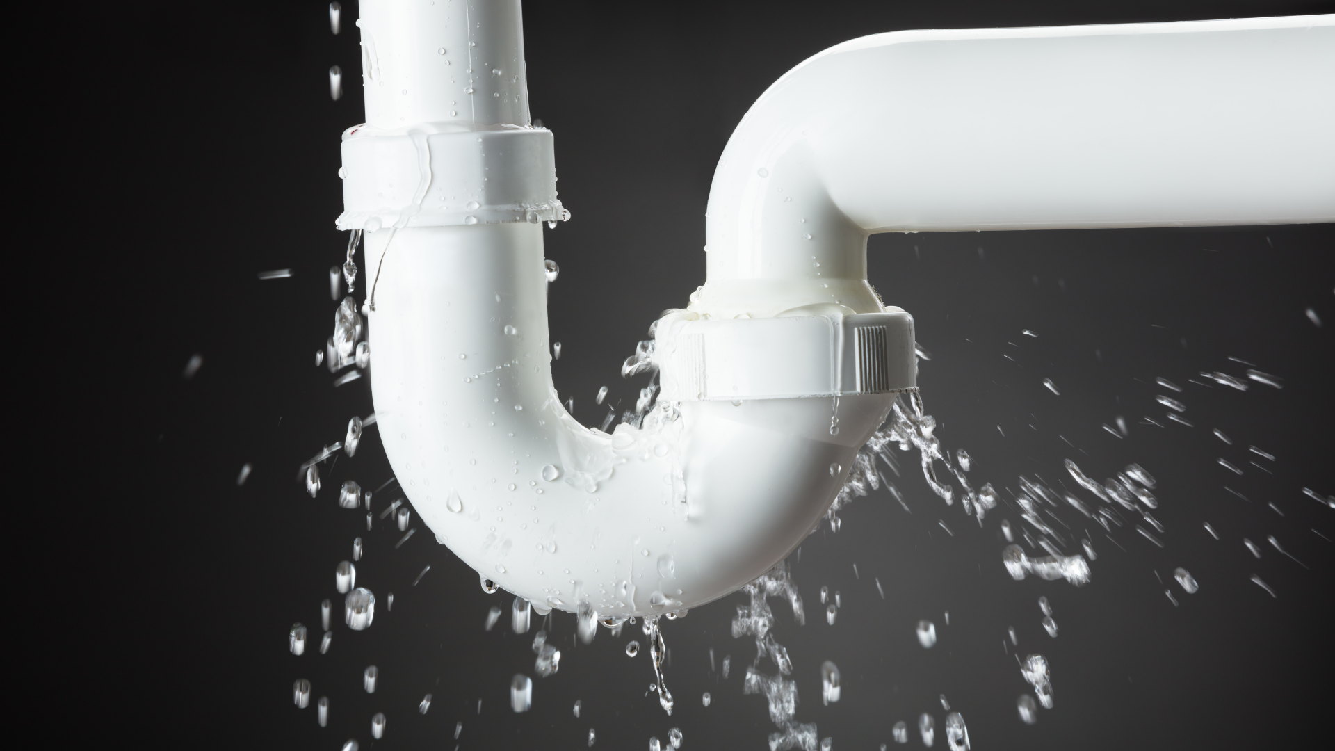 A white pipe is leaking water on a black background.