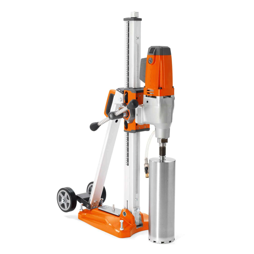 Orange-and-silver core drill rig mounted on a stand, drilling into a concrete cylinder.