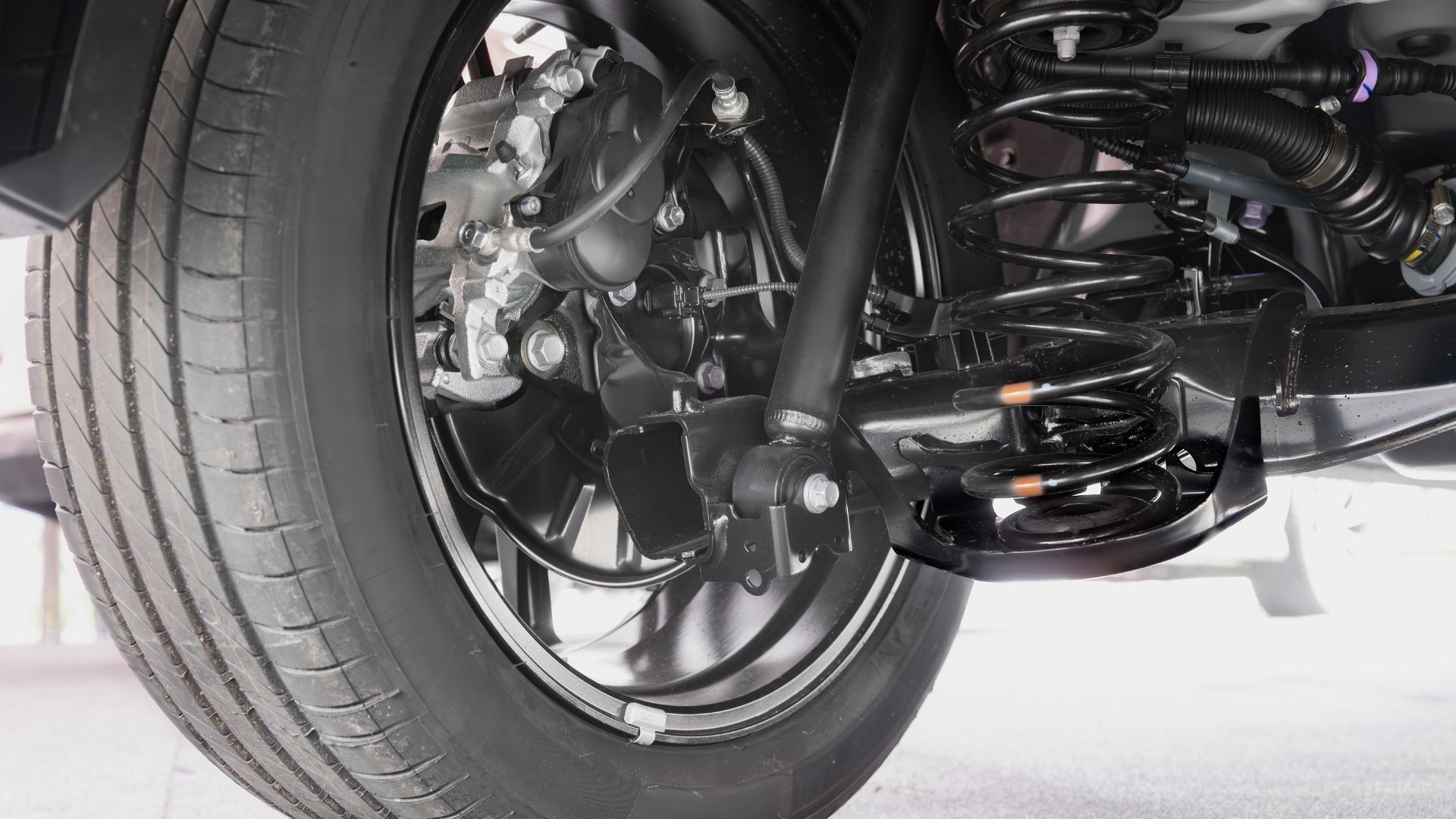 Black car tire and suspension system components.