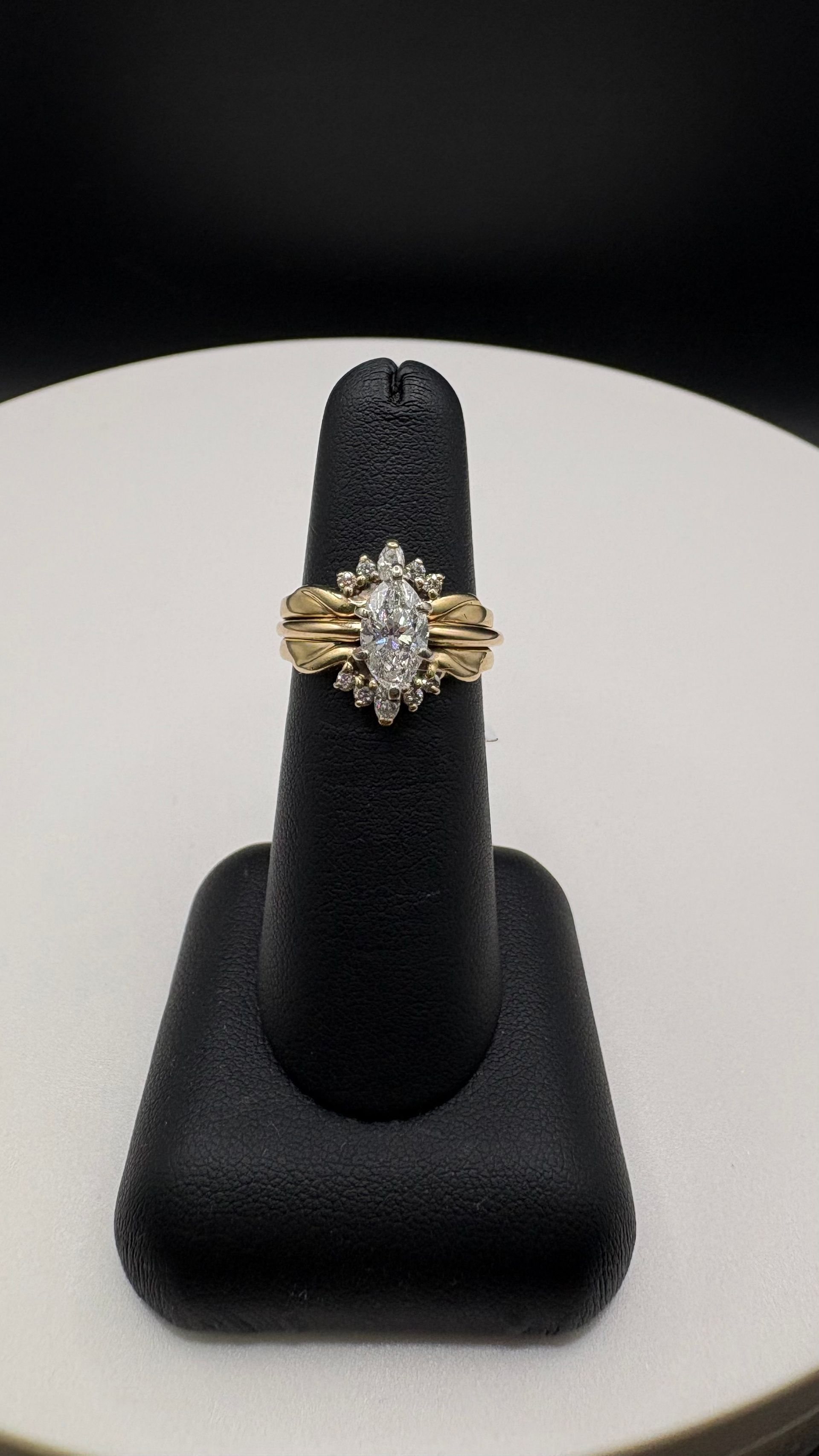 Decorative silver ring with a pale oval stone on a white display stand