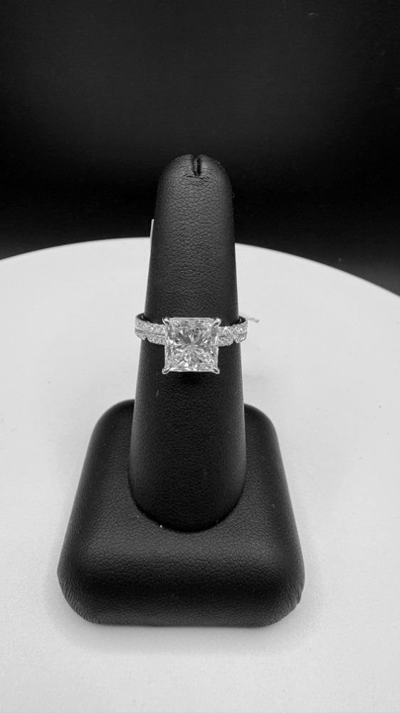 Diamond ring on black display stand against a light background