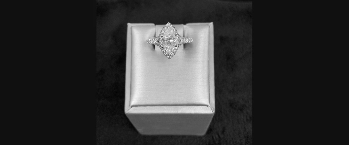 Small silver gift box with a decorative bow on top against a dark background