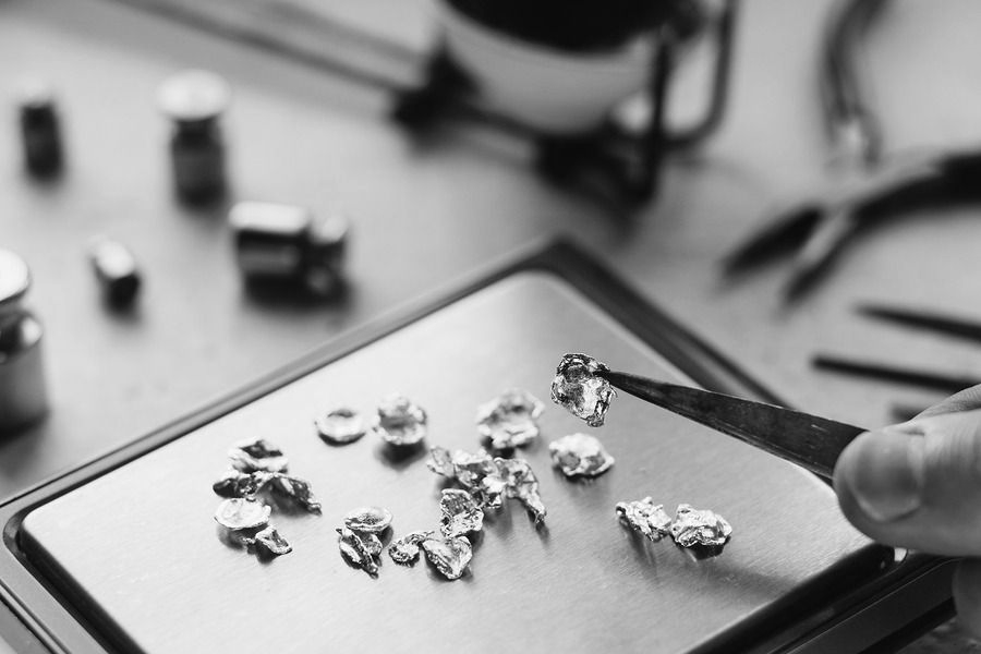 Tweezers placing small stones on a jewelry tray in a workshop