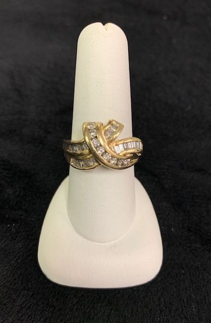 Gold and silver rings stacked on a white display stand against a black background