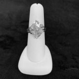 Silver ring on a white display stand against a black background.