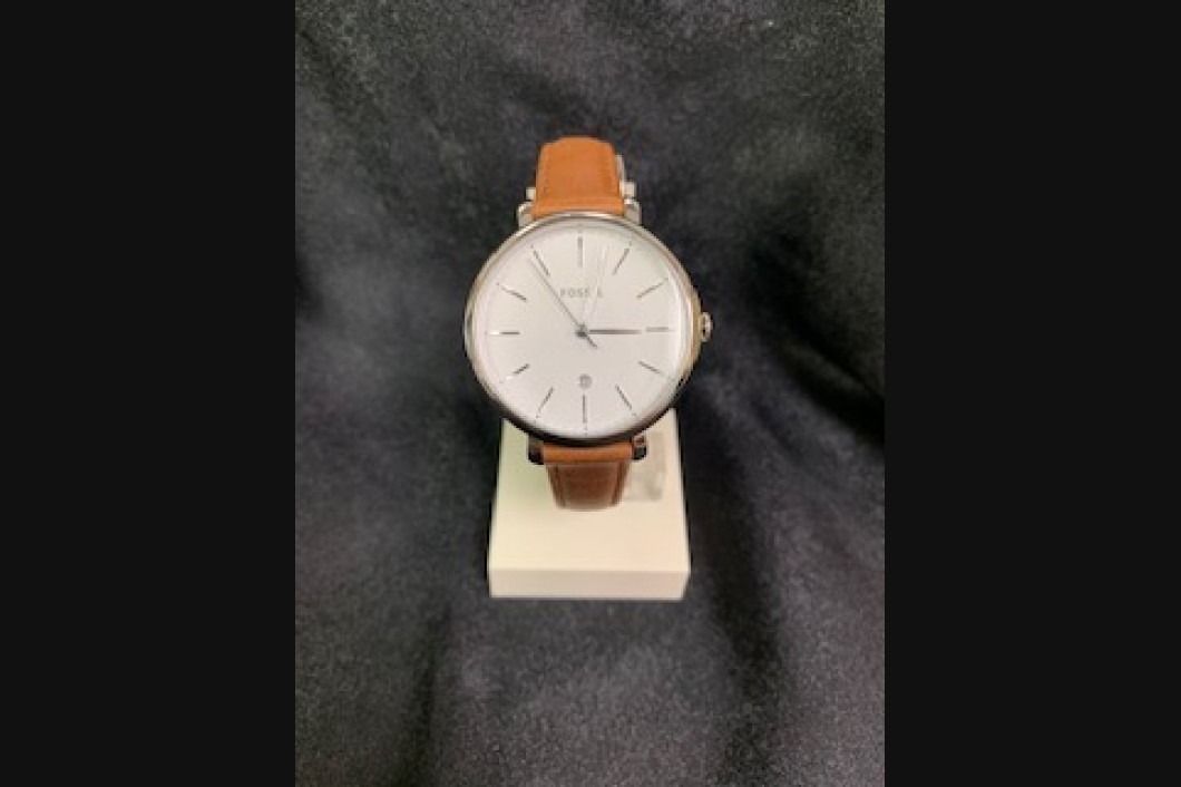 Brown leather strap wristwatch displayed on a white stand against a dark background