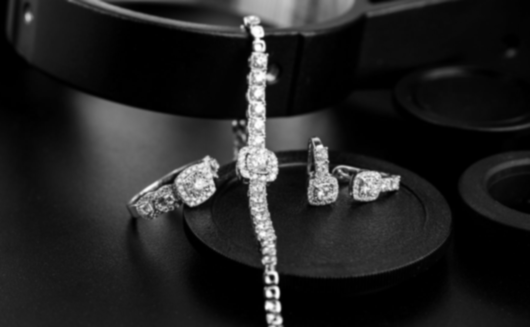 Diamond necklace and matching earrings displayed on a black velvet stand.