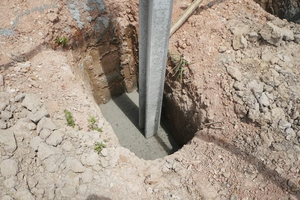 A Metal Pole is Being Installed in a Hole in the Ground — Felto's Concrete Line Pumping in Bellingen, NSW