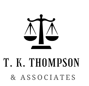 A black and white logo for T.K. Thompson & Associates featuring a scales of justice icon above the company name.