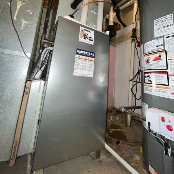 A furnace and water heater in a basement. The furnace is labeled
