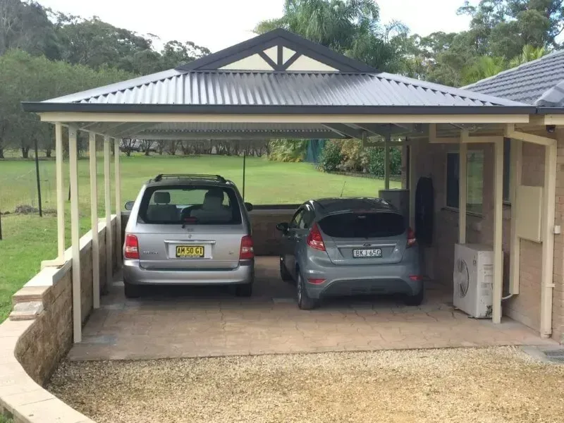 Two Cars Parked Under a Carport with A Dark Roof and Beige Posts— Fair Dinkum Builds Port Stephens in Bobs Farm, NSW
