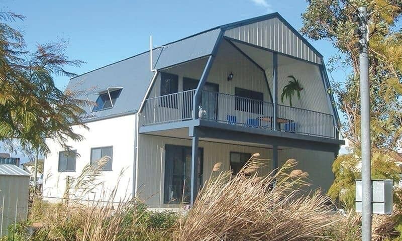 Two-Story Light-Colored House with A Blue Barn-Style Roof and A Balcony — Fair Dinkum Builds Port Stephens in Bobs Farm, NSW