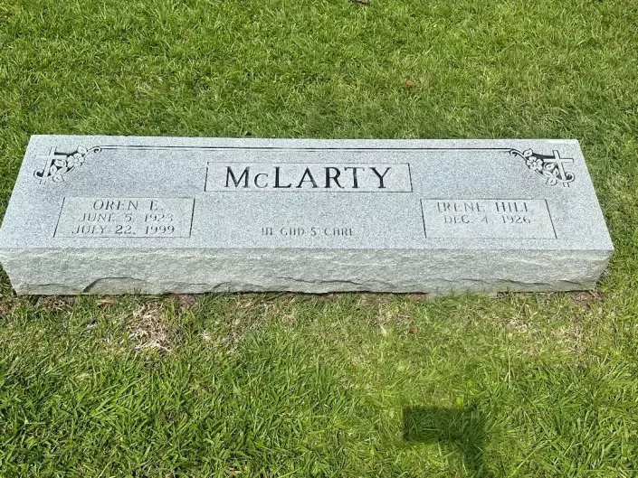 Gray McLarty gravestone lying in grass, with engraved name and decorative corners