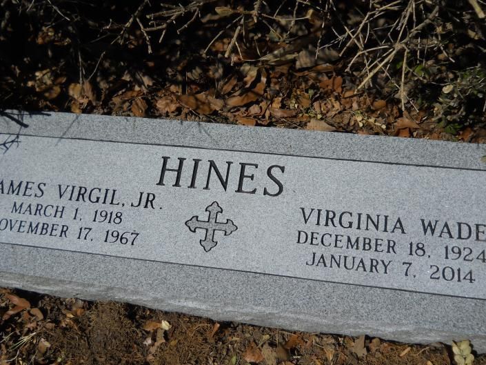 Gray granite gravestone engraved “HINES” with two names and dates in a cemetery.