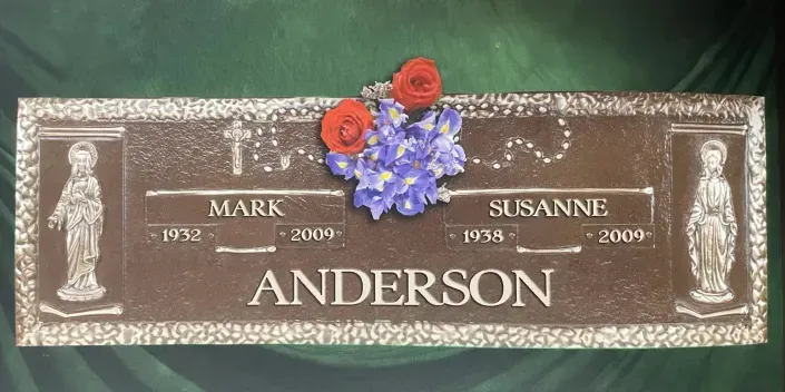Brown memorial plaque with flowers, engraved with the names Mark Anderson and Susanne Anderson