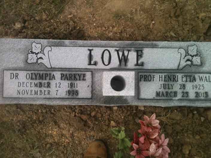 Gravestone for the Lowe family with engraved names, dates, and flowers at the base.