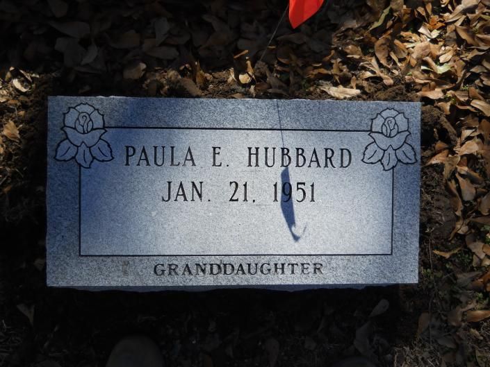 Gray memorial marker engraved “PAULA E. HUBBARD” and “JAN. 21, 1951,” with “GRANDDAUGHTER” below.