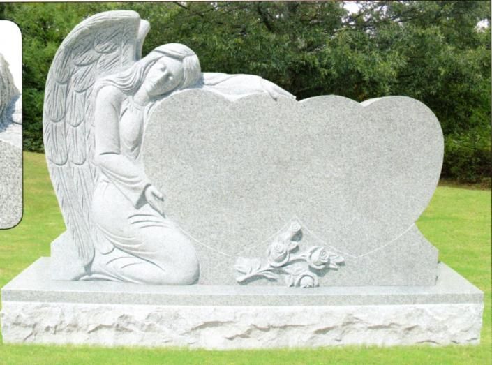 Gray angel gravestone with heart-shaped headstone in a green cemetery background