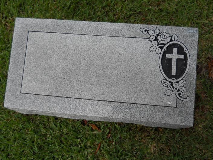 Gray granite gravestone with a cross and floral engraving on the right side.