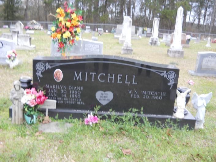 Black Mitchell family headstone with flowers in a cemetery