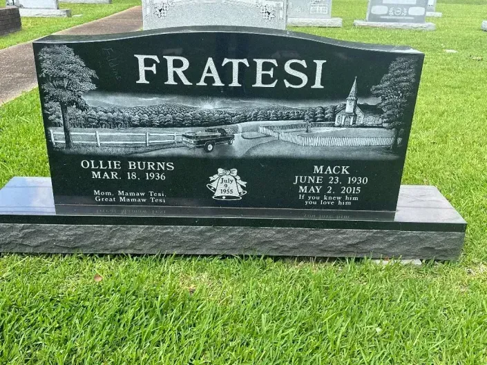 Black granite Fratesi family gravestone with two name plaques in a grassy cemetery