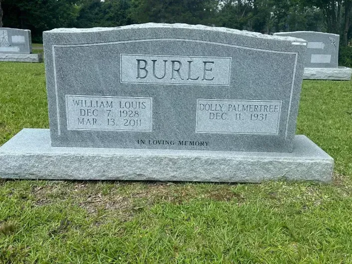 Gray granite BURLE family gravestone in a grassy cemetery