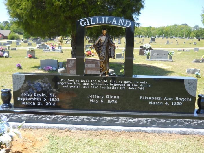 Gilliland family gravestone with a cowboy statue in a grassy cemetery