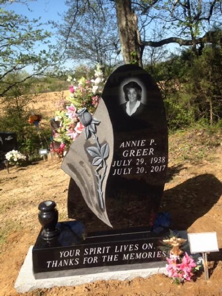 Gravestone with portrait and flowers, engraved “Annie P. Greer” and memorial message.