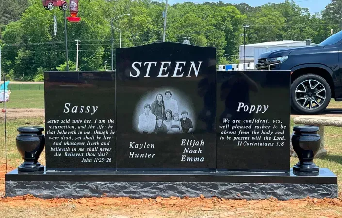 Black memorial grave marker with “STEEN” and names Sassy, Poppy, Koko, and Elliot in a cemetery setting