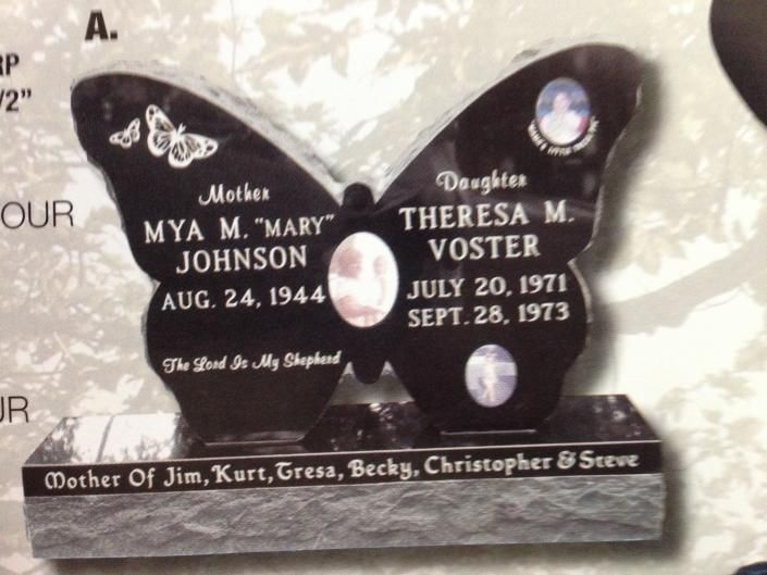Black butterfly-shaped memorial plaque with names and dates engraved on it.