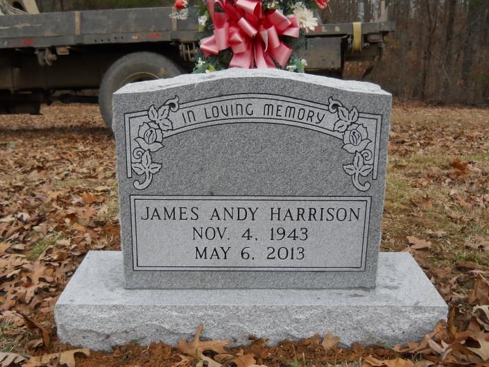 Gray memorial tombstone with a red bow, inscribed “In Loving Memory” for James Andy Harrison.