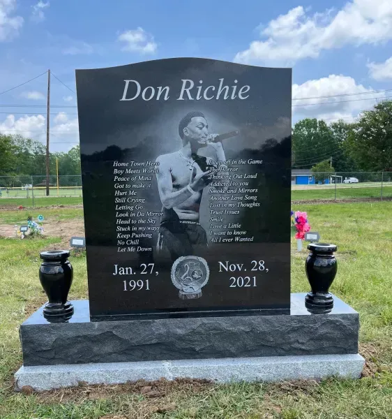 Memorial headstone for Don Richie with etched portrait, black vase planters, and dates Jan. 27, 1991–Nov. 28, 2021