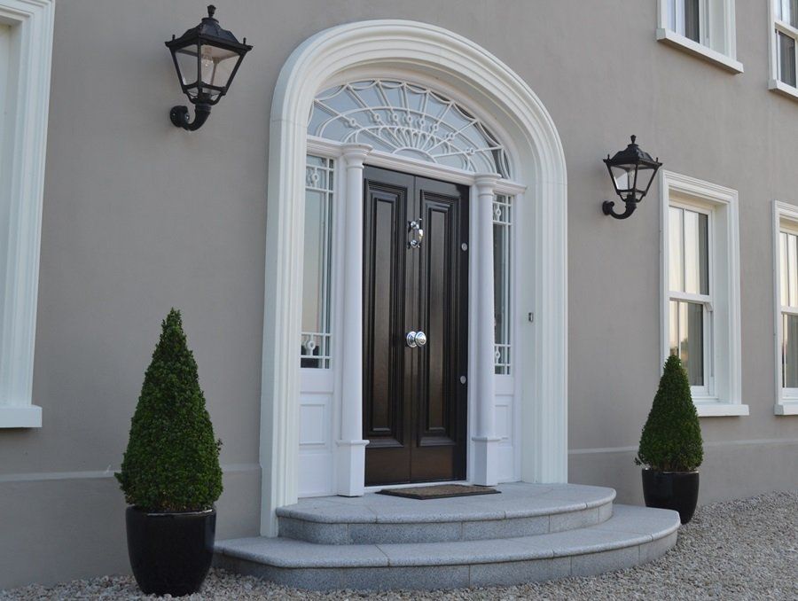 The front door of a house with two potted plants in front of it