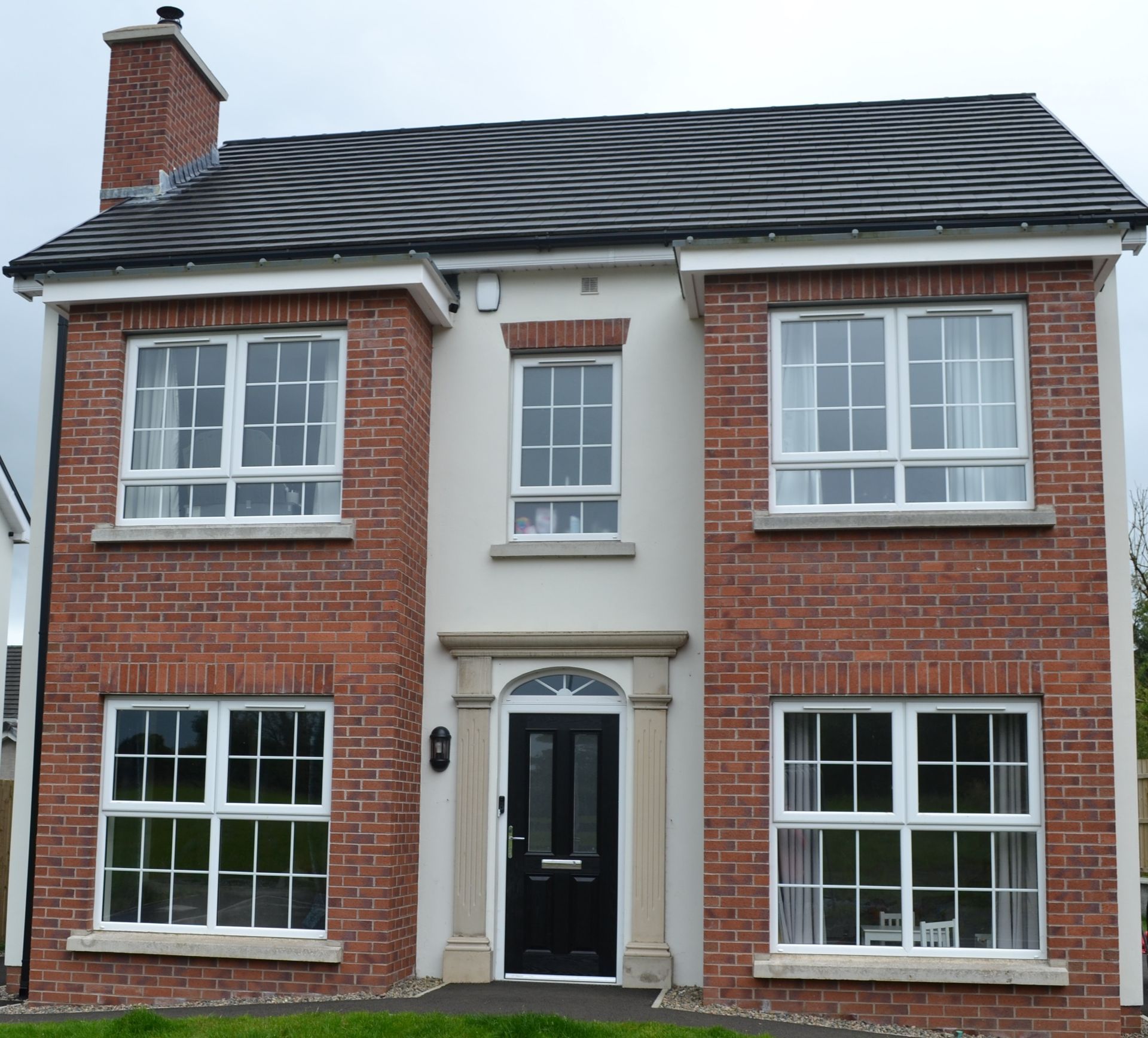 A brick house with a black door and white windows
