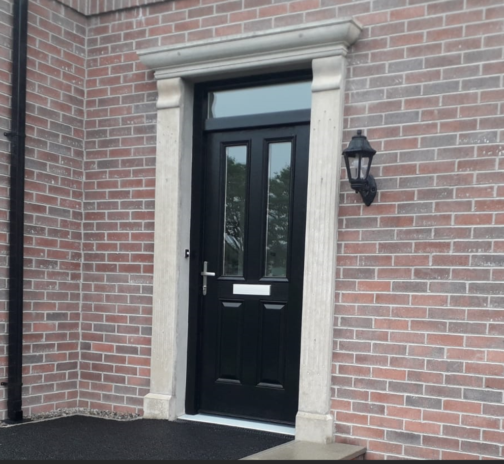 A brick building with a wooden door and a white trim