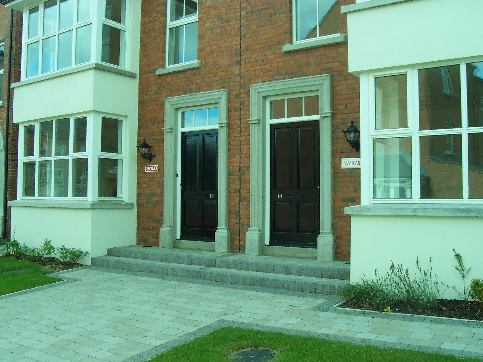 A brick building with two black doors and white windows