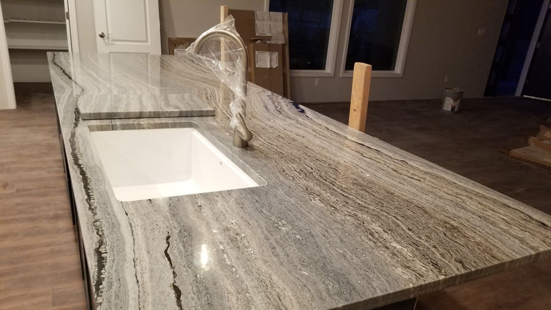 A kitchen with a granite counter top and a sink.