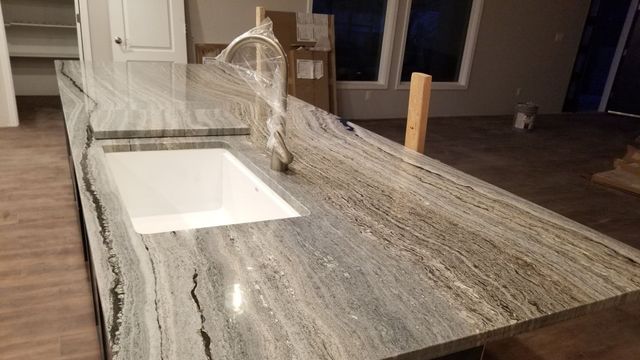 A kitchen with a granite counter top and a sink.