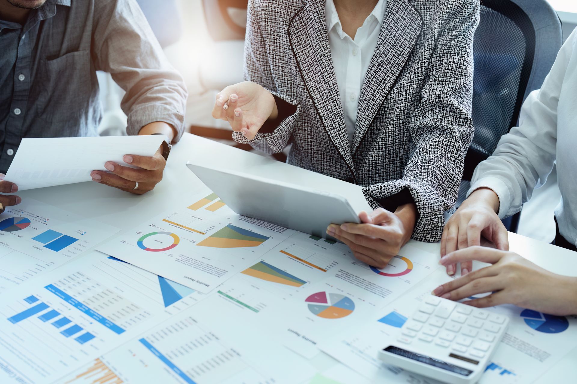 Tax consultants reviewing financial reports and calculations at the table. Tax consultants reviewing financial reports and calculations at the table.