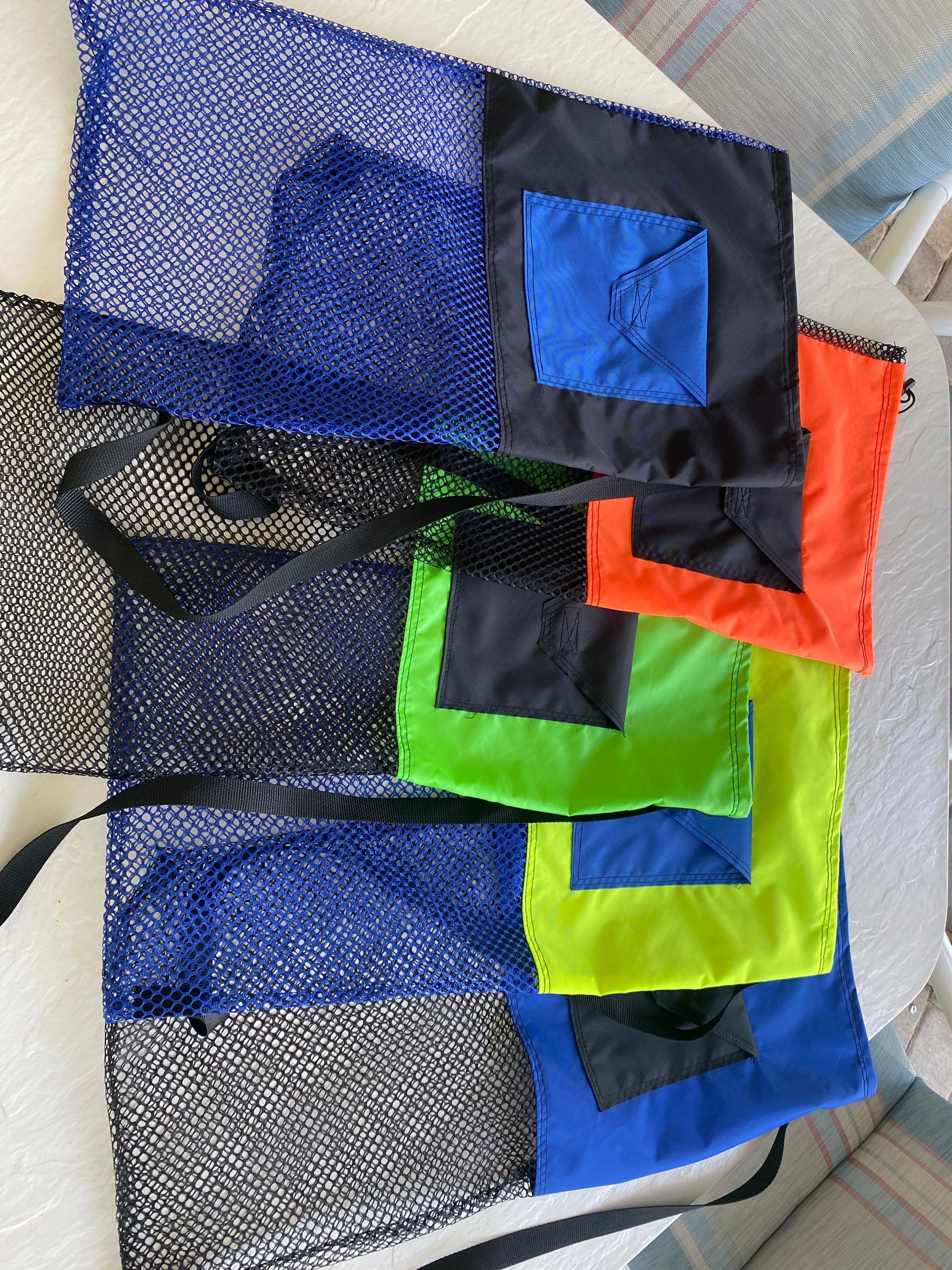 Green and black mesh bag with a drawstring, black strap, and black square on the top.