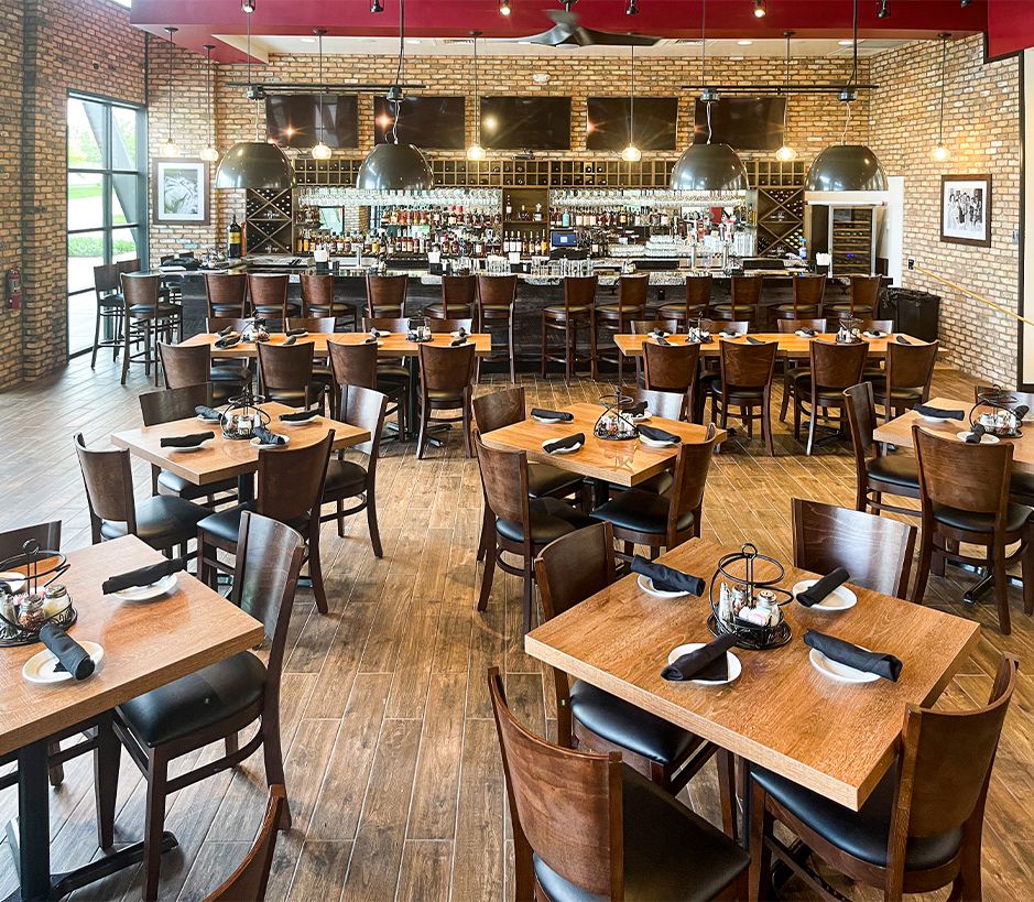 Restaurant interior with wooden tables and chairs, a large bar.