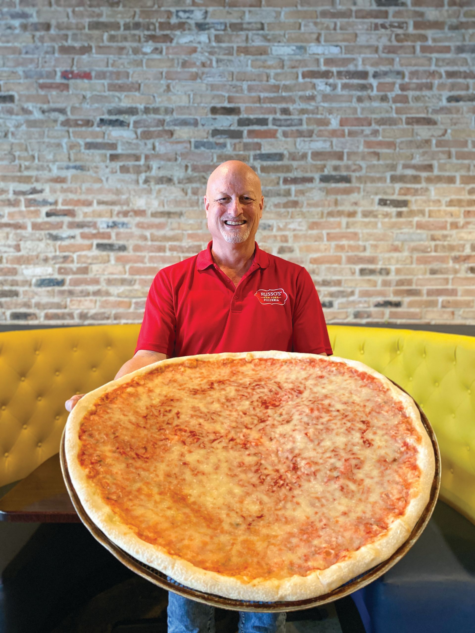 Jeff Lewis holding a pizza.