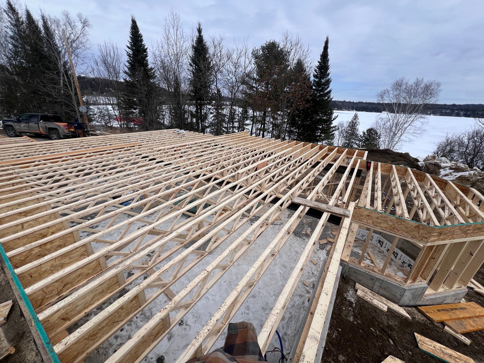 Solives de plancher en bois soutenant un chantier de construction enneigé au bord d'un lac gelé