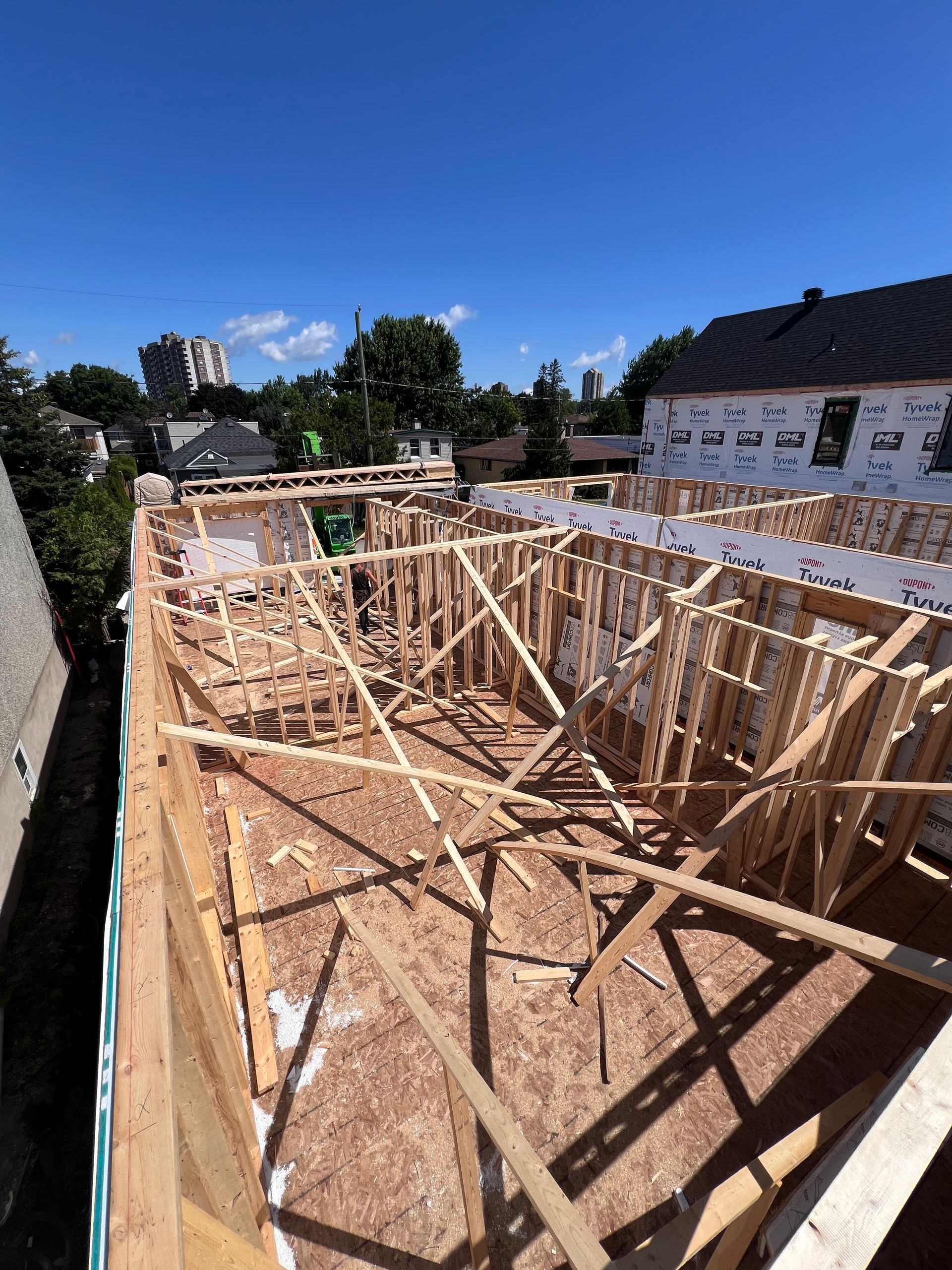 Fondations d'une maison à ossature bois en construction par une journée ensoleillée sous un ciel bleu.