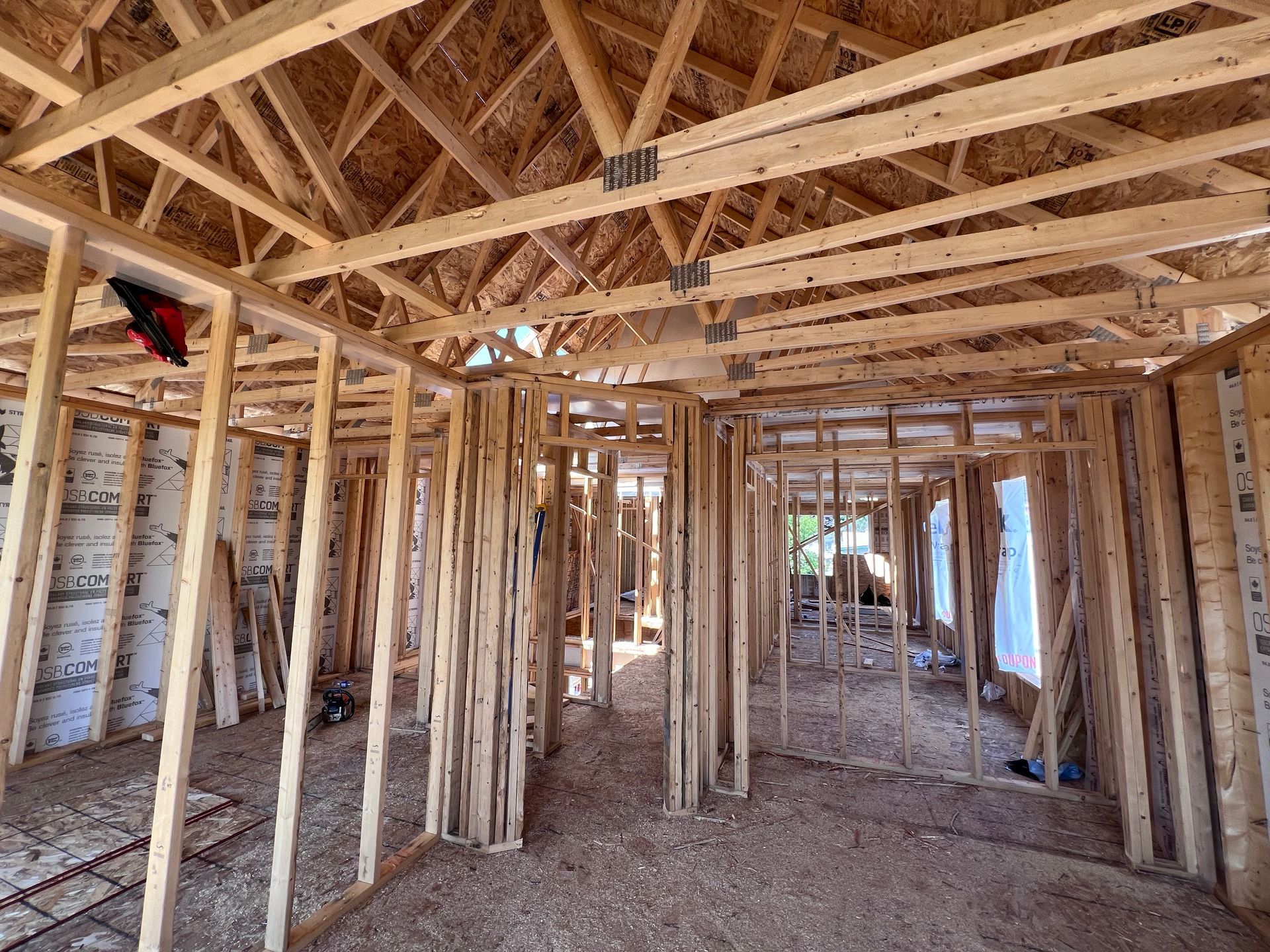 Intérieur d'une maison en construction avec charpente apparente et murs non finis