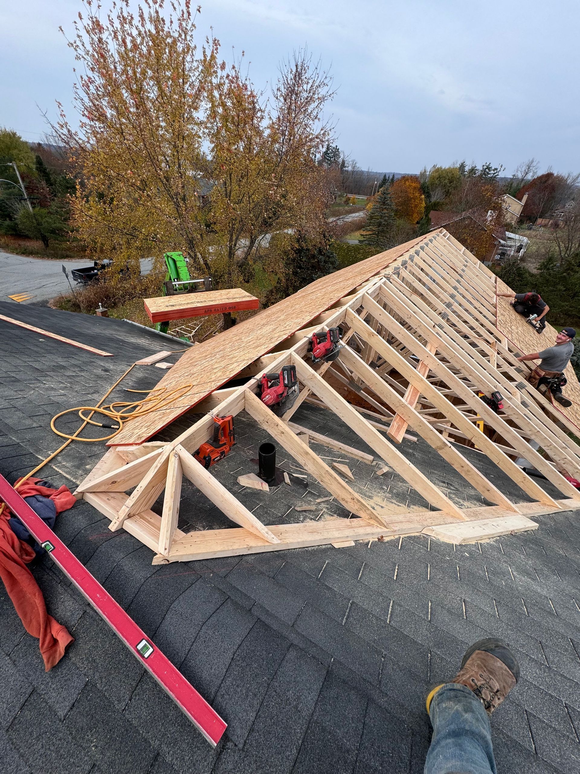 Charpente de toit partiellement en ossature sur un toit plat en construction avec outils et étais en bois