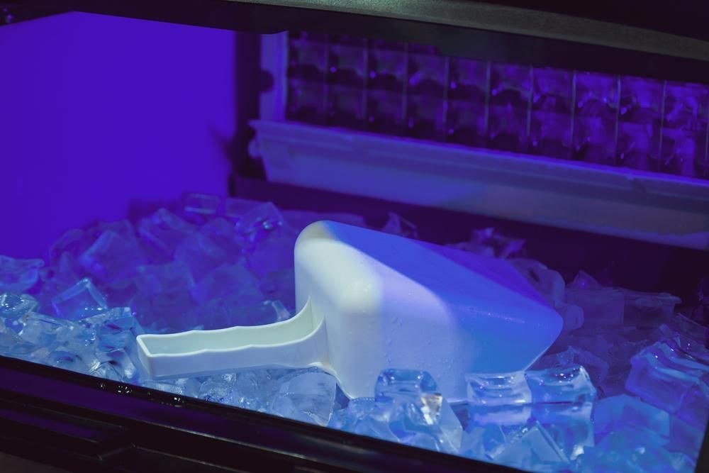 A Scoop Is Sitting on Top of A Pile of Ice Cubes in An Ice Maker — Townsville Stainless Steel in Garbutt, QLD