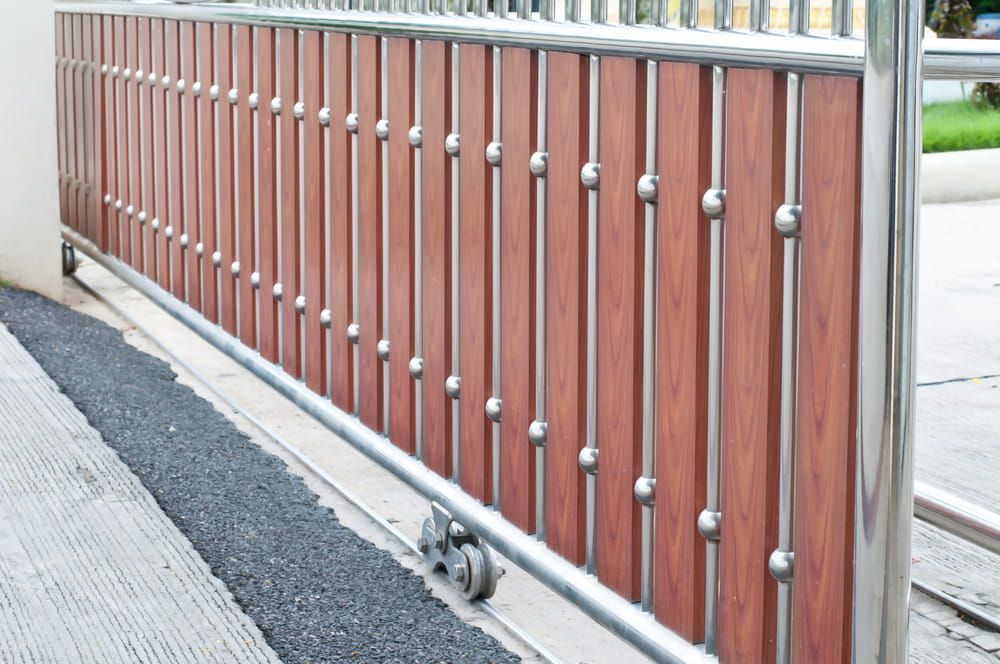 Sliding Gate With Brown Wooden Panels and Stainless Steel Accents — Townsville Stainless Steel in Weipa, QLD