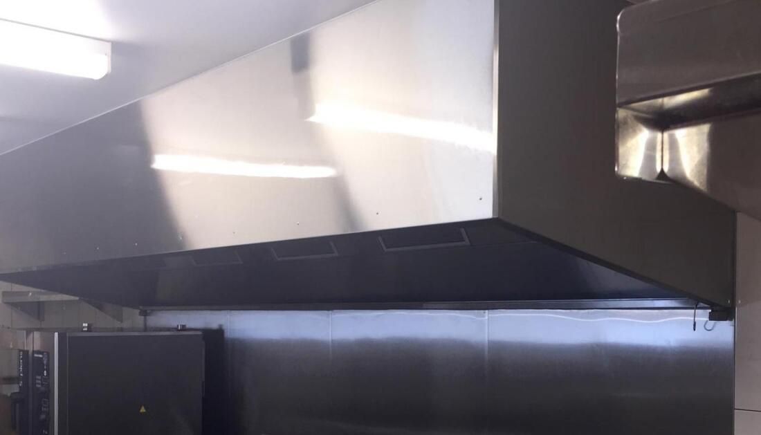 A Stainless Steel Hood Is Hanging from The Ceiling in A Kitchen  — Townsville Stainless Steel in Garbutt, QLD